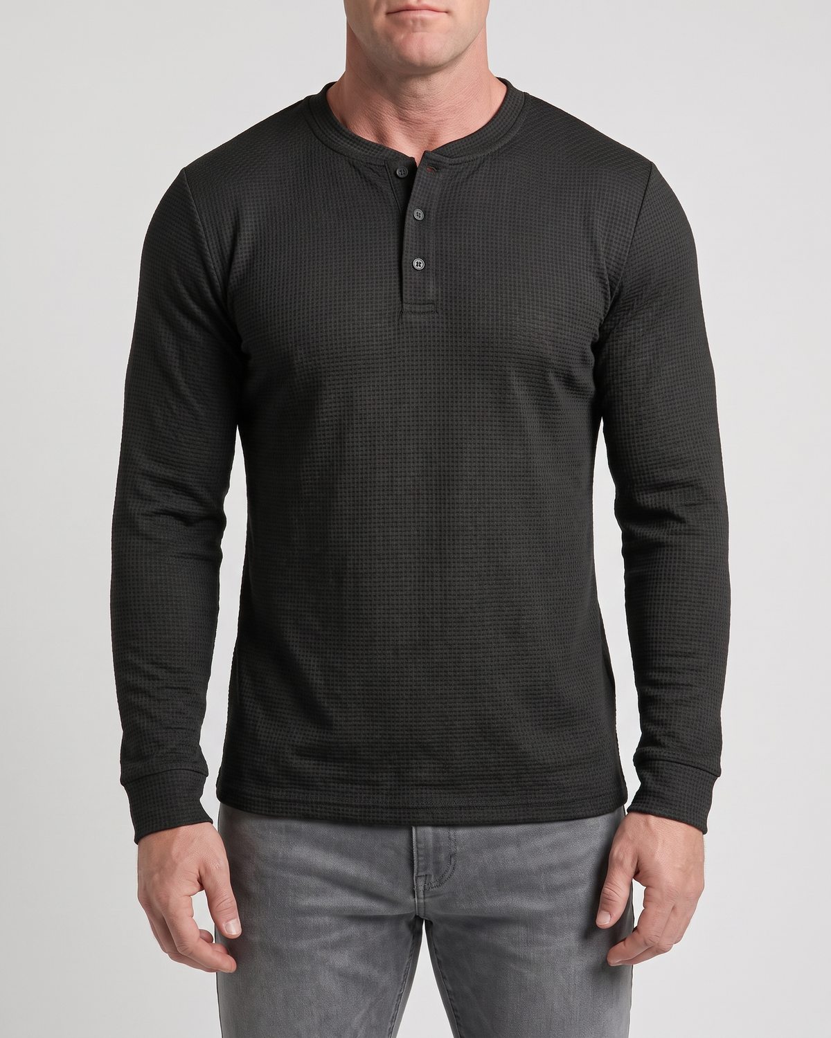 Atlas Waffle Henley in black waffle knit, front view on model with grey jeans